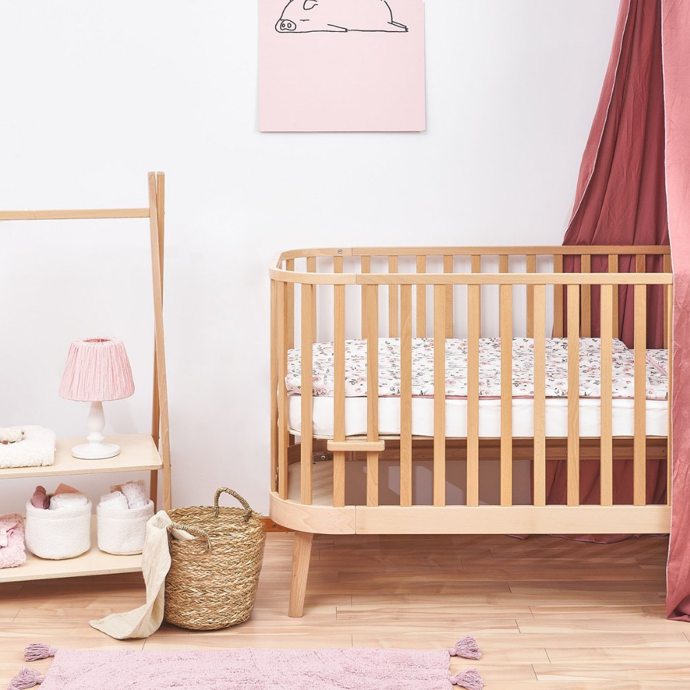 Principal kinderbed hout in babykamer met roze textiel