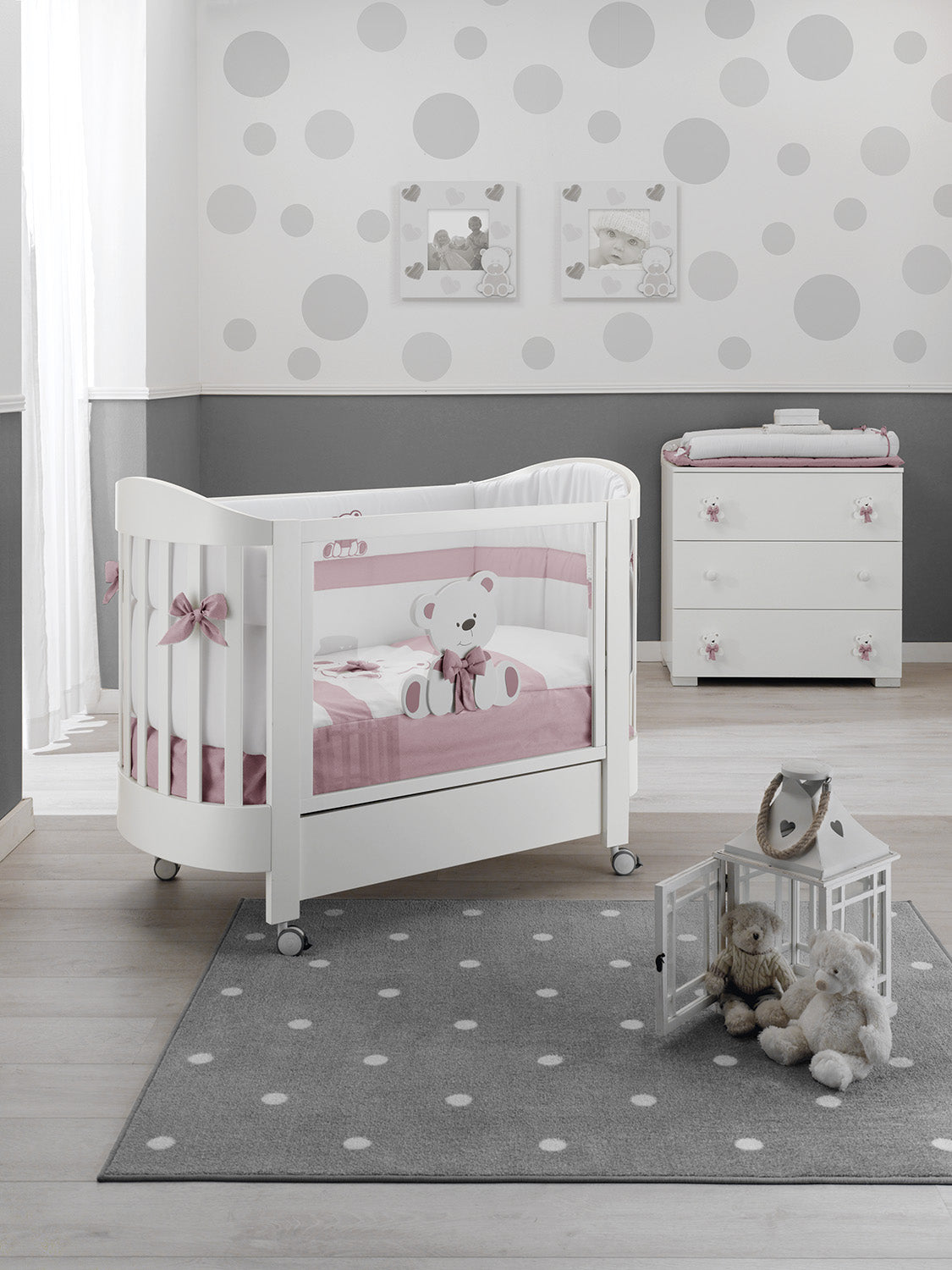Bas ovaal babybed in wit met roze accenten, sfeerbeeld