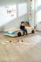Bolide autobed in naturel hout met beddengoed en houten autobaan ernaast