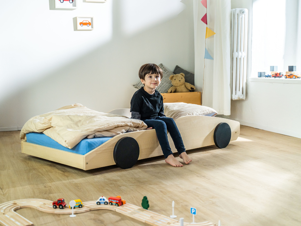 Bolide autobed in transparante olie, kind zit op het bed
