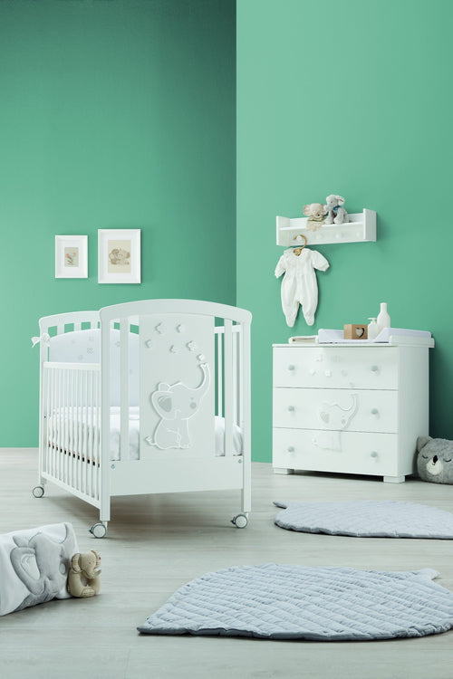 Britt babybed in wit, in een babykamer naast de bijpassende commode