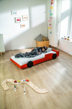 Racer autobed 80×160 in rood, kind slaapt in het bed