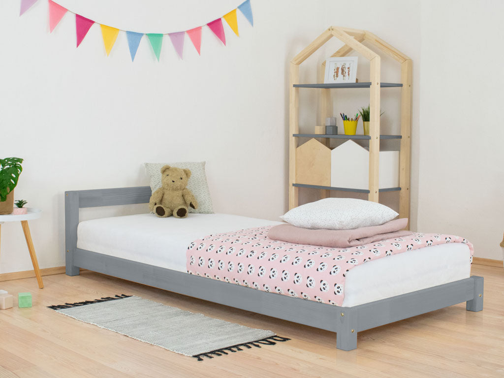 Roos kinderbed met hoofdbord van opzij gezien
