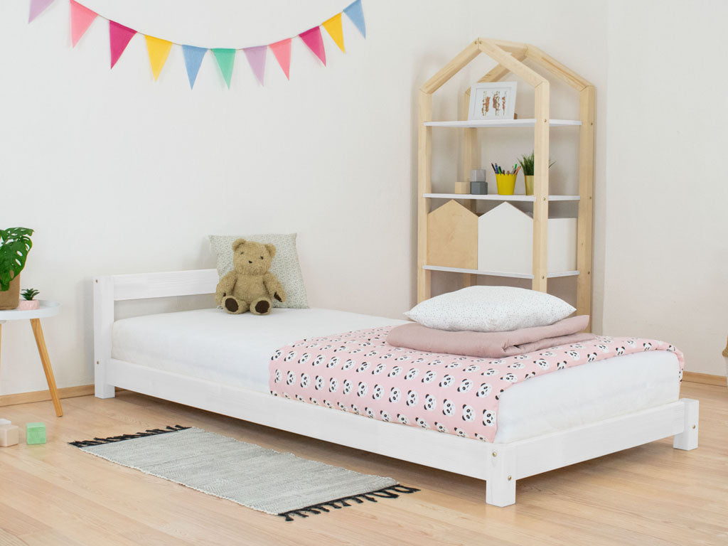 Roos kinderbed met hoofdbord in een kinderkamer