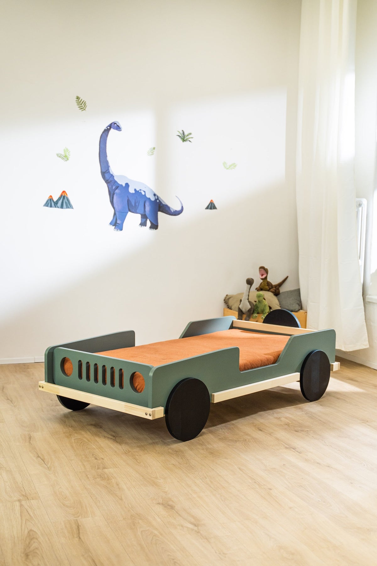 Scout autobed 80×160 in saliegroen met oranje matras in een kinderkamer