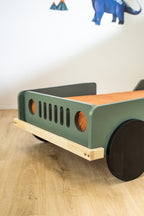 Scout autobed 80×160 in saliegroen, detail van de grille en koplamp met naturel onderstel