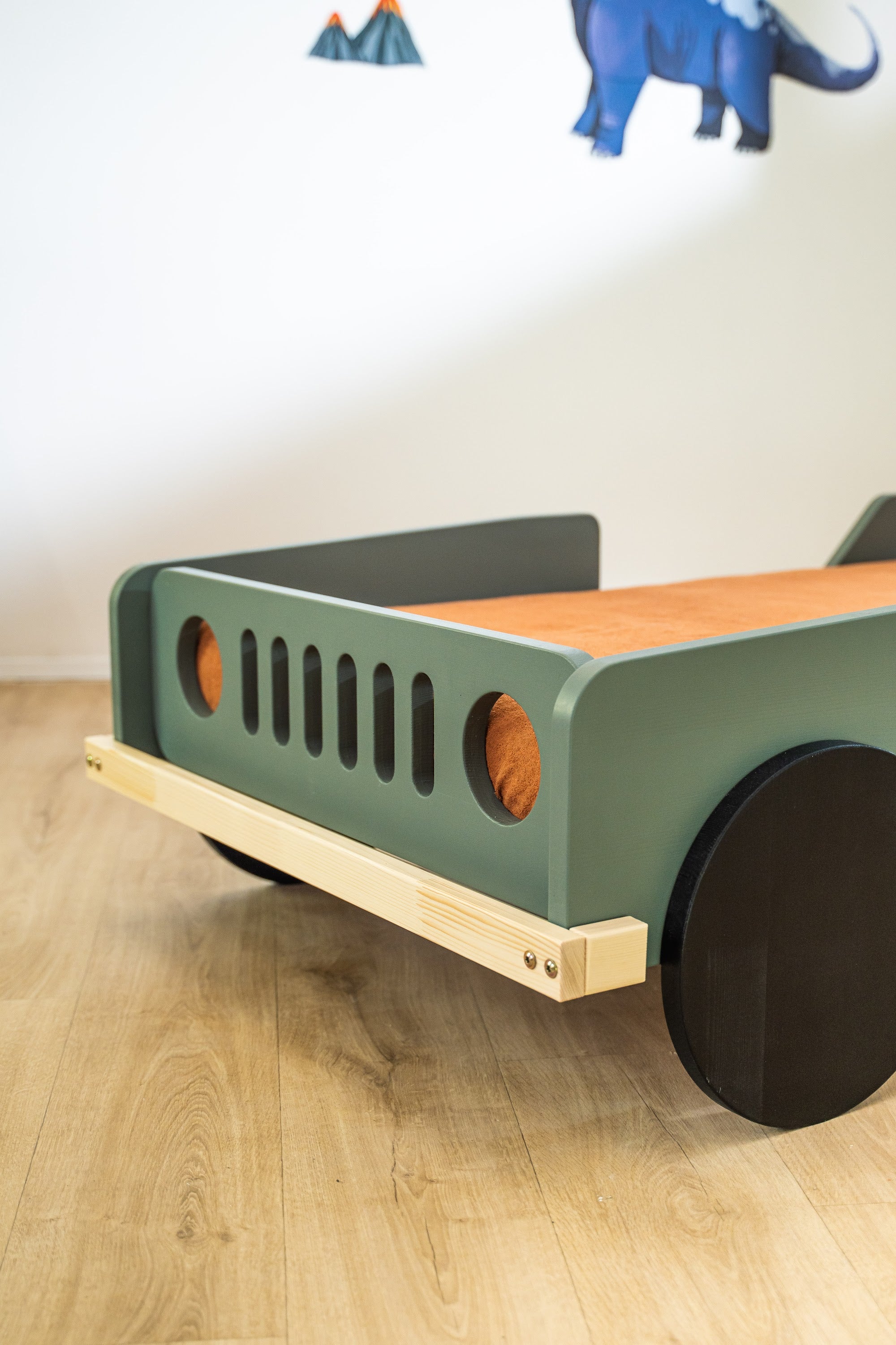 Scout autobed 80×160 in saliegroen, detail van de grille en koplamp met naturel onderstel
