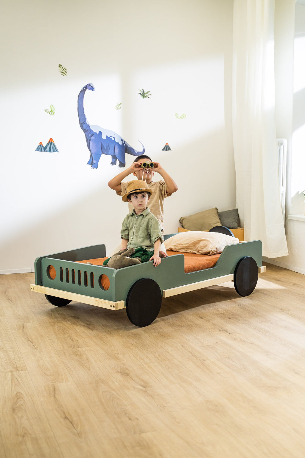 Scout autobed 80×160 in saliegroen, kind met verrekijker op het bed
