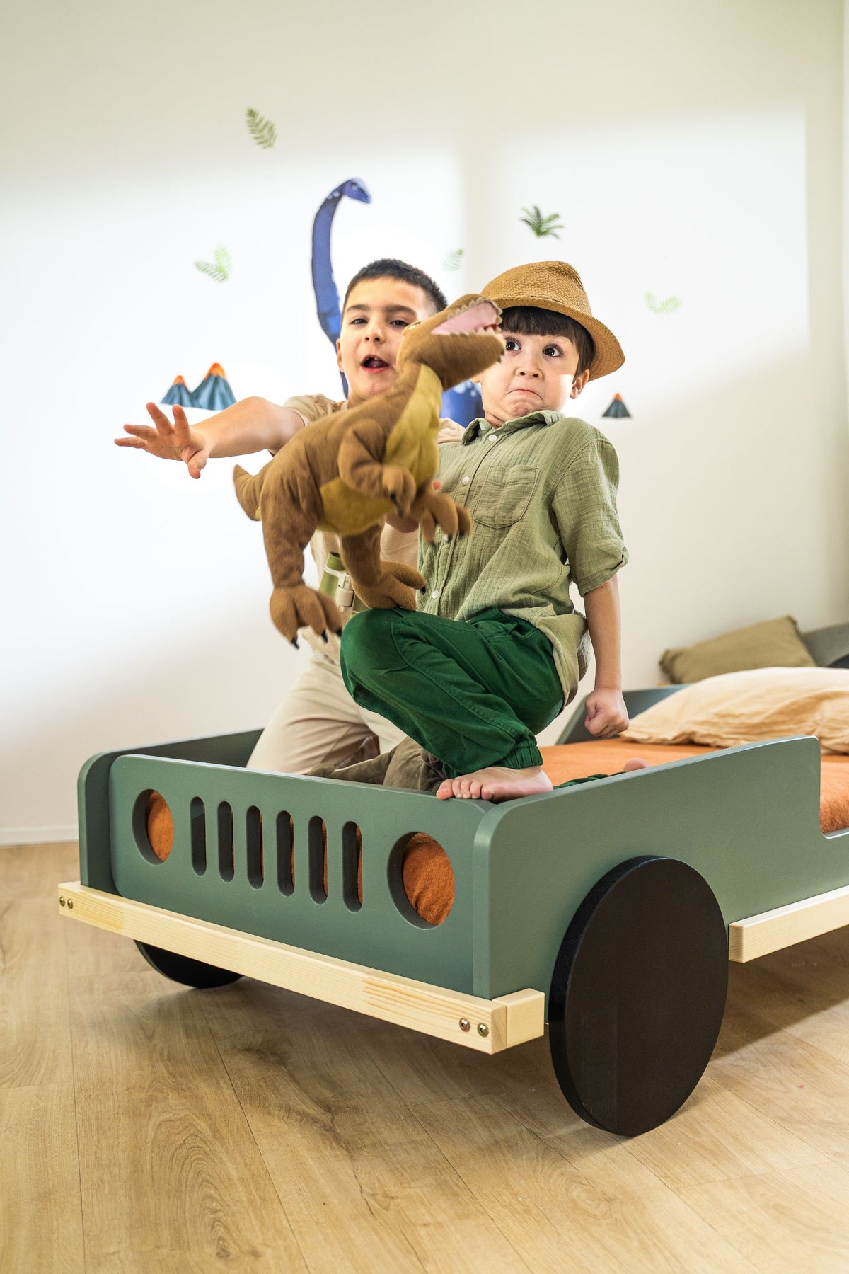 Scout autobed 80×160 in saliegroen, spelende kinderen met knuffeldino op het bed