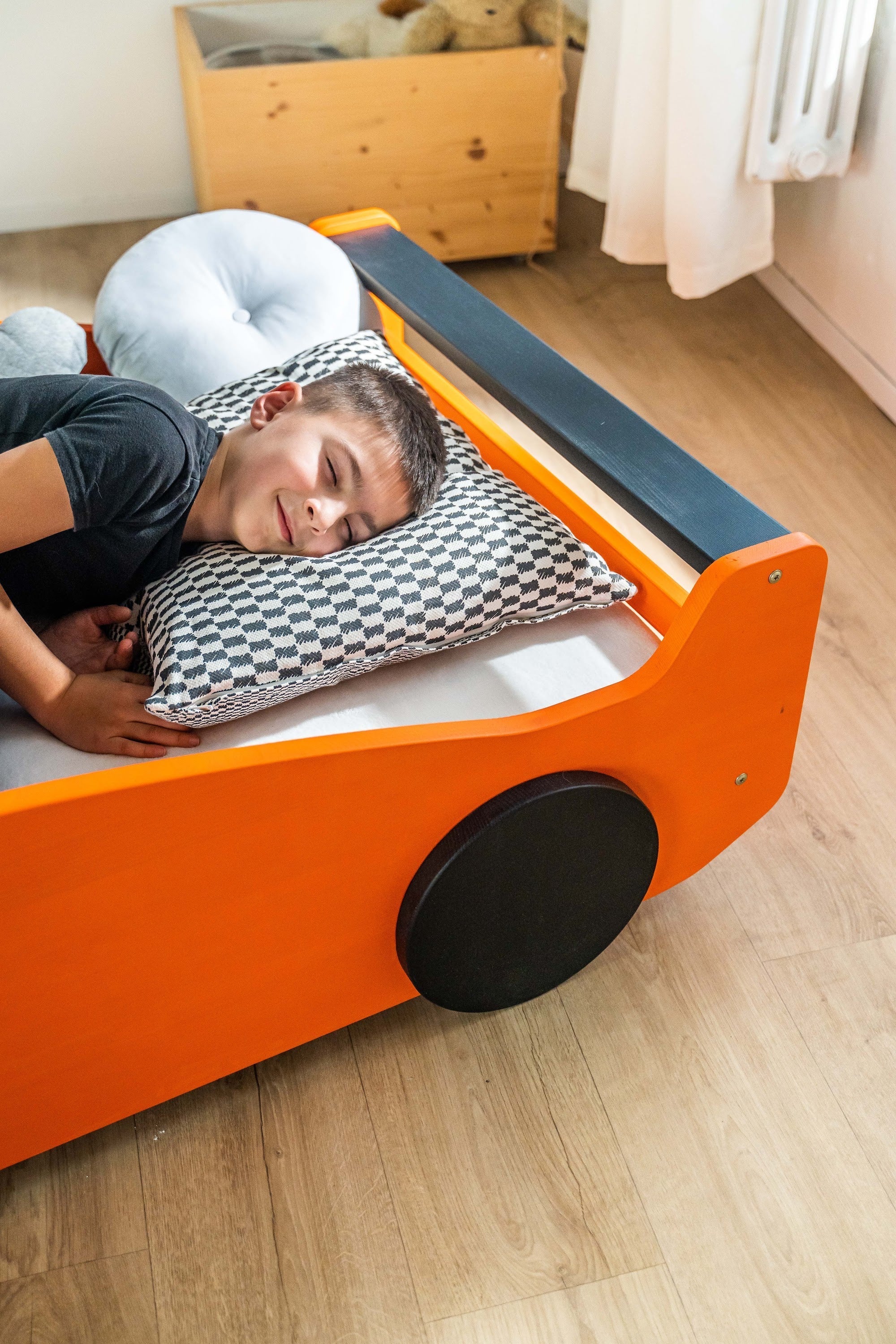 Turbo GT autobed 80×160 in oranje, kind ligt met kussen in het bed